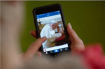  Ein Frau hält ein Smartphone mit dem Instagram-Account von Papst Franziskus in den Händen. Der Papst wird künftig unter "Franciscus" Fotos und kurze Videos auf der Foto-Plattform mit Nutzern in aller Welt teilen.