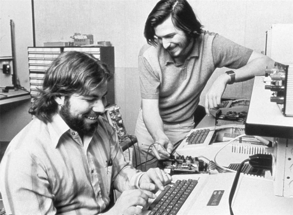 1976: Die Firmengründer Steve Jobs (rechts) und Steve Wozniak bauen in einer Garage die ersten Apple-Computer. Die Geräte, die sie für 666,66 Dollar verkaufen, bestehen nur aus der Hauptplatine, ohne Gehäuse oder Tastatur. Mit Apple beginnt die Ära der Personal Computer, während meist noch Großrechner verwendet werden.