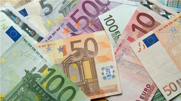  Zahlreiche Euro-Banknoten liegen auf einem Tisch. 