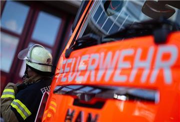ILLUSTRATION - 08.11.2023, Baden-Württemberg, Stuttgart: Eine Einsatzkraft der Feuerwehr steht neben einem Einsatzfahrzeug der Feuerwehr. (zu dpa: «Polizei bittet um Fotos und Videos nach Brand an Silvester») Foto: Marijan Murat/dpa +++ dpa-Bildfunk +++