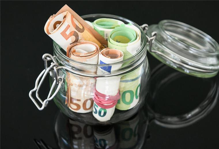 Rollen aus Fünfzig-Euro-Geldscheinen und Hundert-Euro-Geldscheinen stecken in einem Glas mit Bügelverschluss. Ab 2026 ändert sich für Geringverdiener so einiges. 