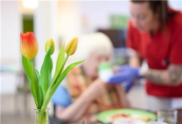 Eine Frau pflegt eine Seniorin, die im Rollstuhl sitzt. Ab Juli 2025 ändern sich die Regeln bei der Pflegeversicherung. Die bringen unter anderem einen neuen Mega-Zuschuss mit sich.