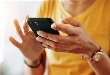 Eine Frau hält ein Smartphone in der Hand. Ab Juni 2025 ändern sich in Deutschland 6 wichtige Regeln. Eine davon betrifft auch Smartphones.