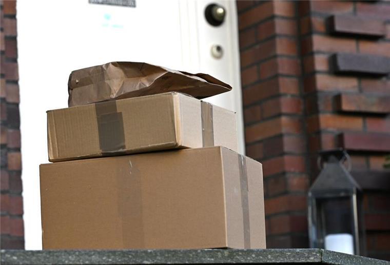 Drei Pakete liegen am Ende einer Treppe vor einer Haustür. DHL wird ab Mai auf einen beliebten Service verzichten.