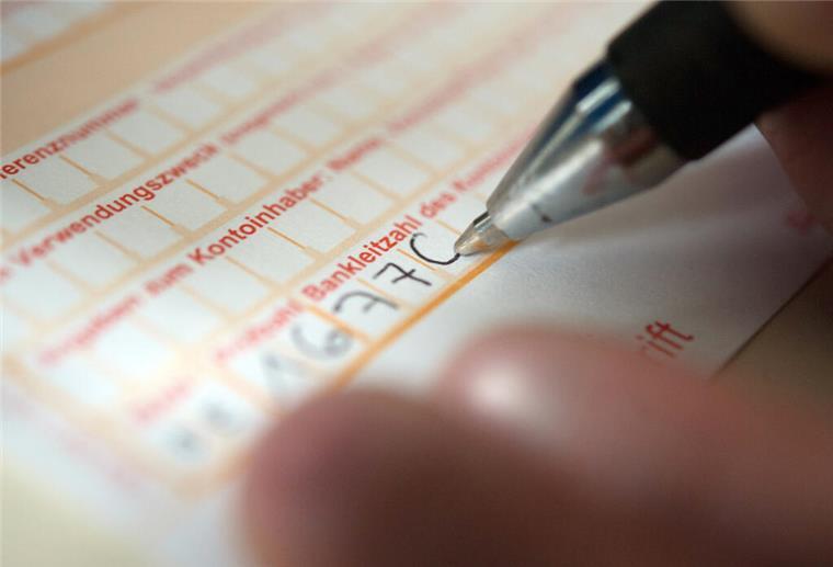 Achtung: Ab Oktober wird neue Sicherheitsprüfung bei Bank-Überweisungen Pflicht Eine Frau füllt ein Überweisungsformular aus.