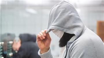 Abu Walaa steht im Oberlandesgericht hinter einer Glasscheibe.