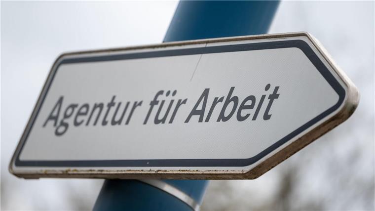 „Agentur für Arbeit“ steht auf einem Wegweiser vor einer Behörde.