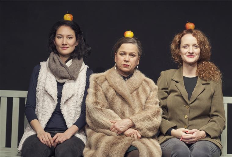 Drei Frauen mit Äpfeln auf dem Kopf