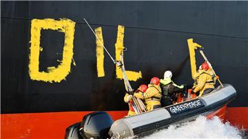 Aktivisten der Umweltorganisation Greenpeace malen den Schriftzug „Oil fuels war“ auf den Rumpf eines Schiffes, das russisches Öl auf der Ostsee transportiert. (Archivbild)