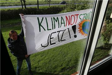 Aktivisten machen mit einem Transparent am Mittwoch vor dem Kreishaus in Cuxhaven deutlich: Der Kreistag soll den Klimanotstand erklären. 
