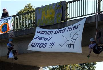 Klima-Aktivisten seilen sich von einer Brücke über der A27 ab und bringen Plakate an.