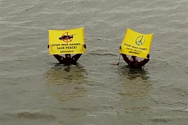 Aktivisten von Greenpeace halten Plakate in die Luft.