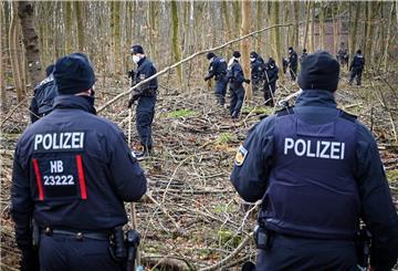 Polizisten durchsuchen ein Waldgebiet.