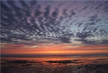 Die Sonne geht über der Nordsee unter. 