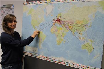 Aleksandra Rupietta zeigt an einer Weltkarte, wo überall in der Welt Bremerhavener Studenten studieren.