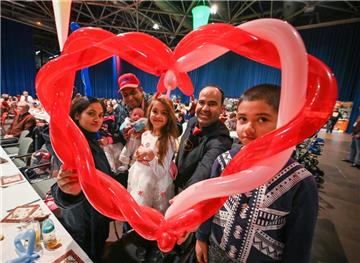 Alexis Vaiou begrüßt zum Essen für Bedürftige in der Stadthalle. V. li. Somera Sohel, Sarwar Sohel mit Suhan, Shama, Alexis Vaiou und Sherin (v. li.). 
