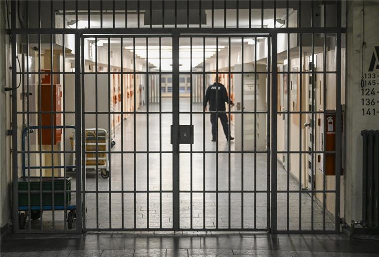  Ein Vollzugsbeamter öffnet in der Justizvollzugsanstalt Moabit bei der Vorstellung der Pläne für einen Suizidpräventionsraum eine Zellentür in einem mit Gittern gesicherten Zellengang. 