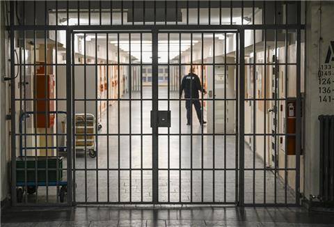  Ein Vollzugsbeamter öffnet in der Justizvollzugsanstalt Moabit bei der Vorstellung der Pläne für einen Suizidpräventionsraum eine Zellentür in einem mit Gittern gesicherten Zellengang. 