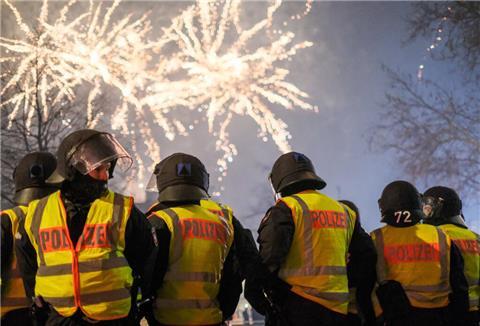 Polizeibeamte stehen in Hannover in der Innenstadt und beobachten ein Feuerwerk.