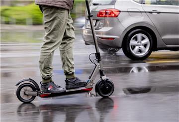 Ein Mann fährt mit einem E-Scooter auf der Straße.