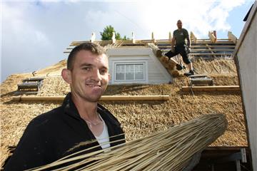 Altes Handwerk: Norbert Guta (vorne) und sein Kollege Sándor Hajzer decken ein Haus mit Reet ein. 