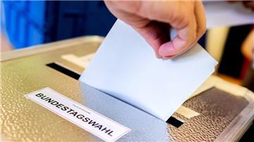 Ein Wahlzettel wird in eine Wahlurne gesteckt