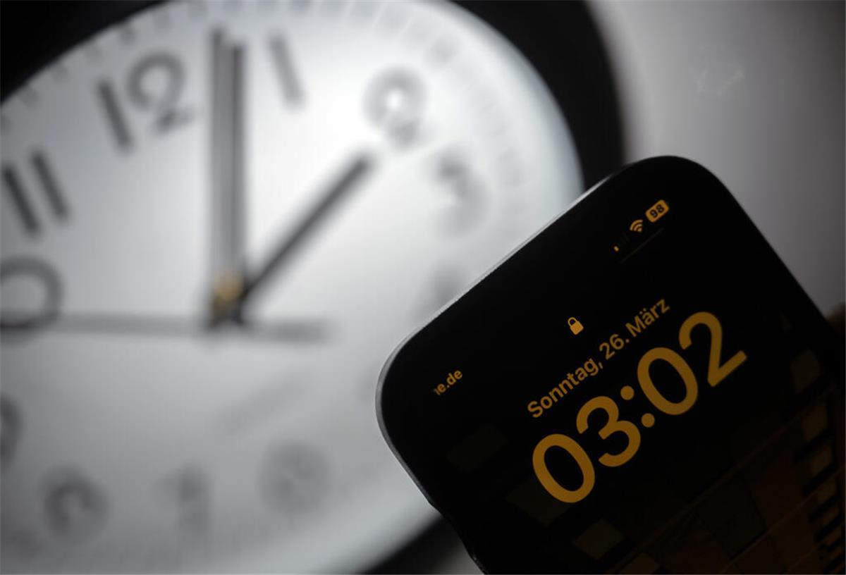 Ihr wollt keine Zeitumstellung mehr: Das sind Eure Antworten Ein Smartphone zeigt die Uhrzeit «03:03» an, während auf einer analogen Uhr noch 02:03 Uhr ist.