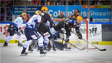 Mehrere Eishockeyspieler kämpfen vor einem Tor um den Puck.