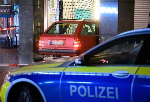 Ein Auto steht im zerstörten Eingangsbereich eines Pfandleihhauses.
