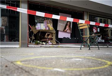 Markierungen der Spurensicherung sind vor der abgesperrten, beschädigten Ladenfront zu sehen. 
