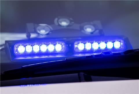 Ein Blaulicht leuchtet unter der Frontscheibe eines Einsatzfahrzeugs der Polizei