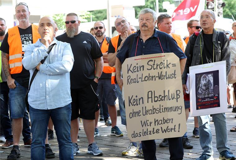 Hafenarbeiter in Bremen stehen mit Plakaten auf der Straße.