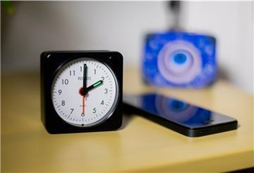 Ein Wecker auf einem Nachttisch zeigt 2 Uhr.