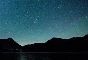 ARCHIV - 12.08.2018, Bayern, Einsiedl: Eine Sternschnuppe leuchtet neben der Milchstraße am Himmel über dem Walchensee. .. (zu dpa: «Höhepunkt der Leoniden-Sternschnuppen erwartet») Foto: Matthias Balk/dpa +++ dpa-Bildfunk +++