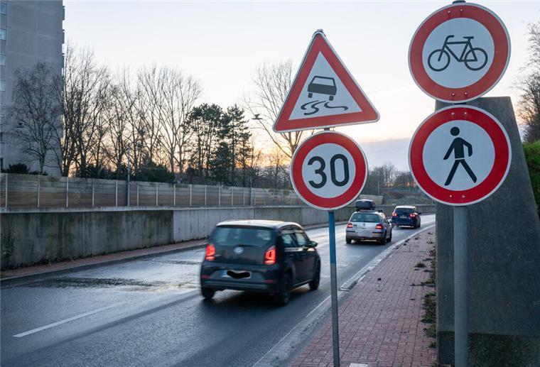 Vorsicht Glättegefahr: Am Hafentunnel bleibt die Straße nass Schilder weisen neben einer Straße auf Glättegefahr hin. Es gilt Tempo 30. Daneben fahren Autos.