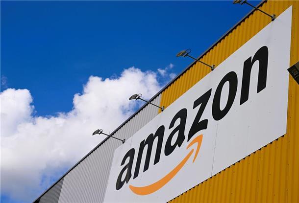 Das Logo des Online-Händlers Amazon ist an der großen Lagerhalle seines Logistikzentrums zu sehen.