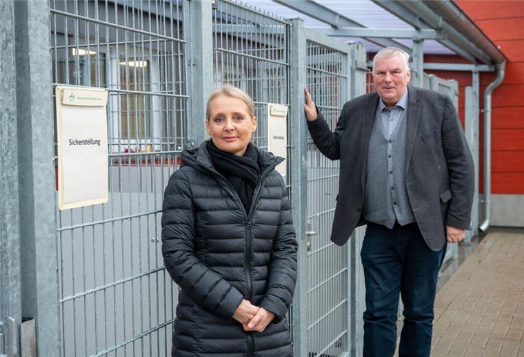 Zwei Personen vor einem Tierkäfig