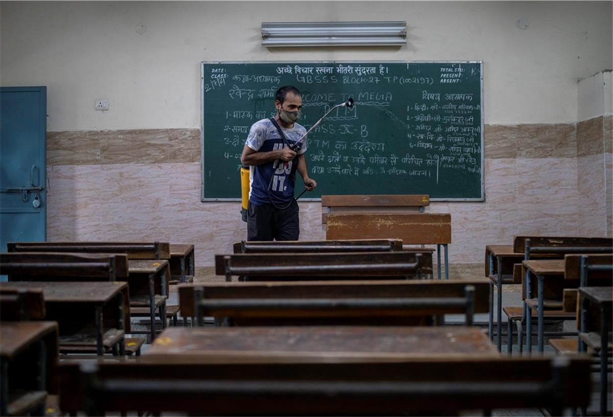 Amtsärzte dringen auf einheitliche Quarantäneregeln an Schulen Ein Mann desinfiziert ein Klassenzimmer vor der teilweisen Wiedereröffnung der Schulen.