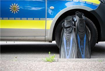 Flossen eines Polizeitauchers stehen an einem Polizeiauto
