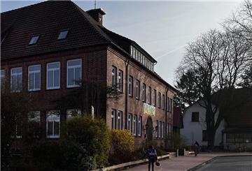 Ein Kind geht zum Eingang einer Schule.