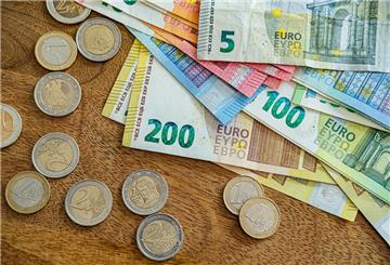Geldscheine und Münzen liegen auf einem Tisch. An der Kasse wird's entspannter: Die Inflation ist gesunken – aber nicht in allen Bereichen. Dienstleistungen bleiben teuer, und neue Preisrisiken sind nicht vom Tisch.