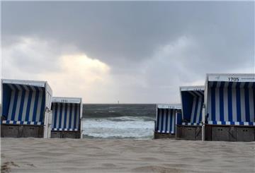 Leere Strandkörbe vor aufgepeitschter Nordsee