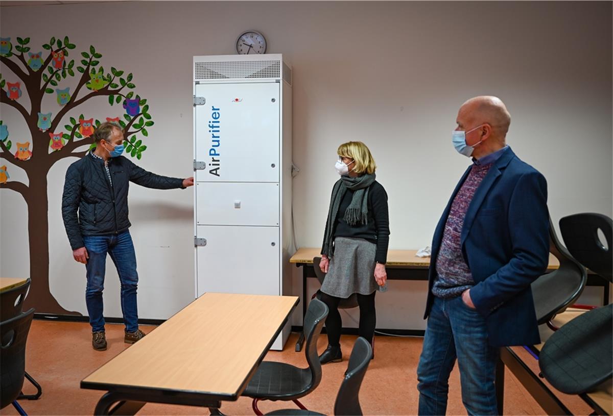An der Oberschule im Schulzentrum Carl von Ossietzky sind Luftreiniger aufgestellt worden. Der technische Leiter von Seestadt Immobilien Holger Schneeberg erklärt Ulrike Baumgart-Gruhn und Georg Mondwurf (v. i.) die Funktion.