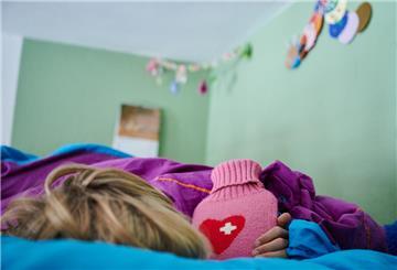 ILLUSTRATION - 11.09.2021, Berlin: Ein Kind liegt mit einer Wärmflasche im Bett im Kinderzimmer. (zu dpa: «Viele Schulkinder in Deutschland sind krank») Foto: Annette Riedl/dpa +++ dpa-Bildfunk +++