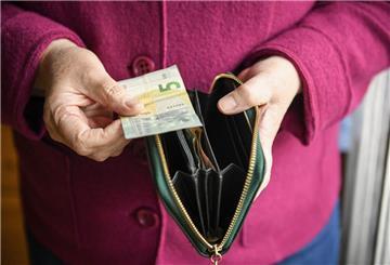  Eine ältere Frau hält eine mit einigen Geldscheinen gefüllte Geldbörse in einer Hand und einen Fünf-Euro-Schein in der anderen Hand, Andere Länder sind bei der Rente weit voraus: Niederlande, Österreich und Dänemark bieten deutlich höhere Rentenniveaus – und zeigen, was möglich ist, wenn alle einzahlen und langfristig gedacht wird.