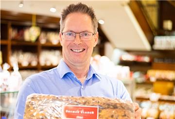 Andreas Knigge, ist neben seinem Bruder Harald, Inhaber von Café und Konditorei in der Sögestraße. In den Händen hält er einen frischen verpackten Klaben.