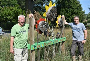 Andreas Pape (rechts) und Mario Löhden werten ihre Blühfelder mit Nisthilfen für Insekten auf. Dieses bunte Exemplar haben die beiden Landwirte von einem Anbieter aus dem Münsterland bekommen.