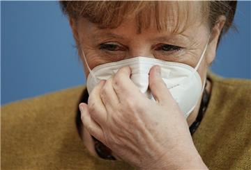 Bundeskanzlerin Angela Merkel (CDU) setzt nach einer Pressekonferenz zur aktuellen Lage das Haus der Bundespressekonferenz ihre Schutzmaske auf.
