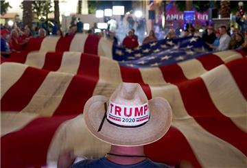 Anhänger von Präsident Donald Trump schwenken während einer Wahlparty eine Flagge. 