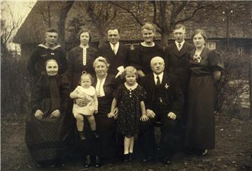 Annemarie Gerken (rechts) im Kreise ihrer Familie in Iselersheim. Die Aufnahme entstand mutmaßlich in der zweiten Hälfte der 30er Jahre und zeigt Claus Gerken, Gesche Gerken, Karsten Hinrich Gerken, Lene Gerken und Diedrich Gerken (stehend von links) sowie Adelheid Engelke, Helma Gerken, Annemaries Mutter Lucia, Traute Gerken und Annemaries Vater Karsten Gerken (von links).